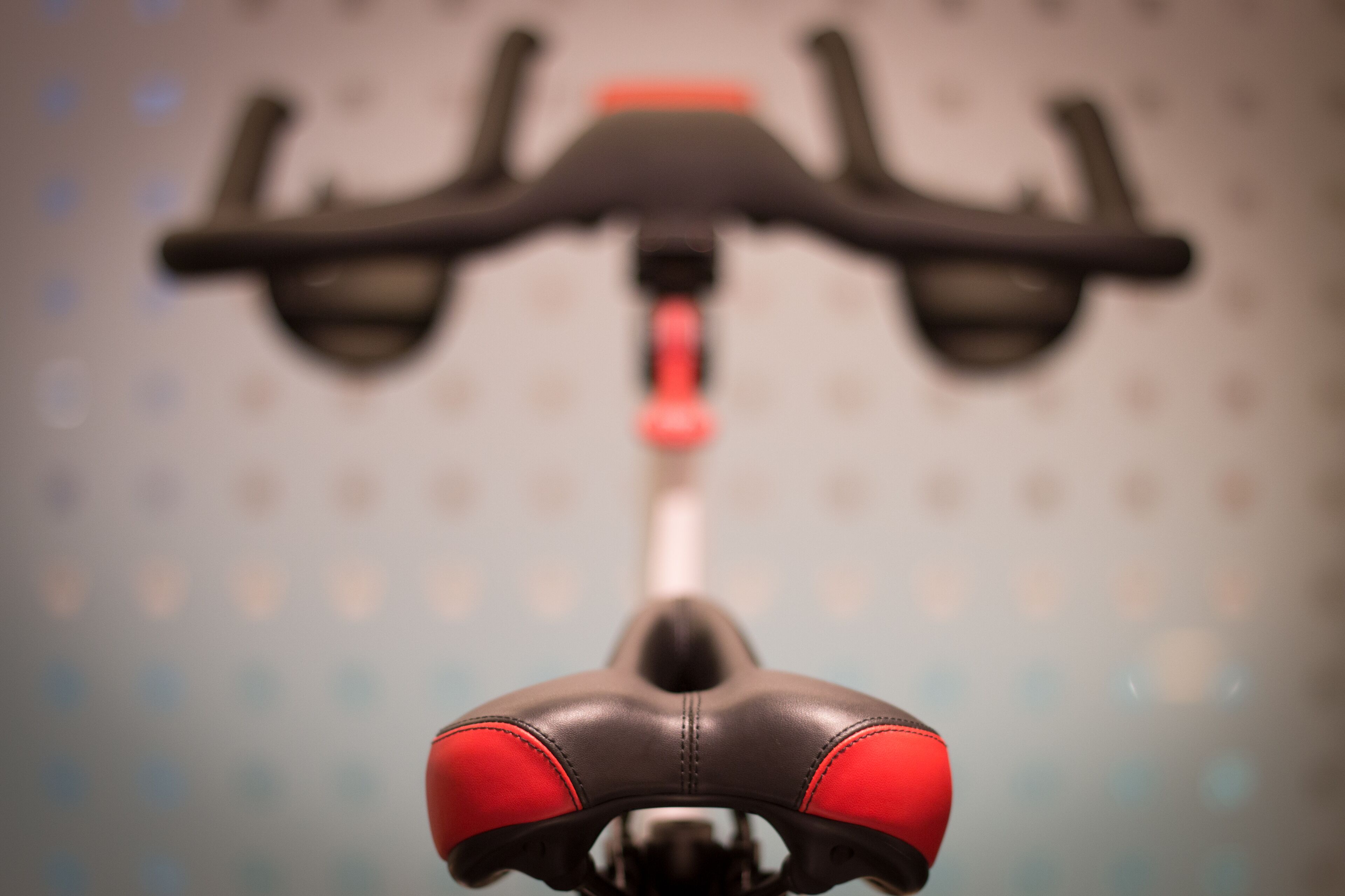 Close-up de um selim de bicicleta com detalhes em vermelho e um guidão.