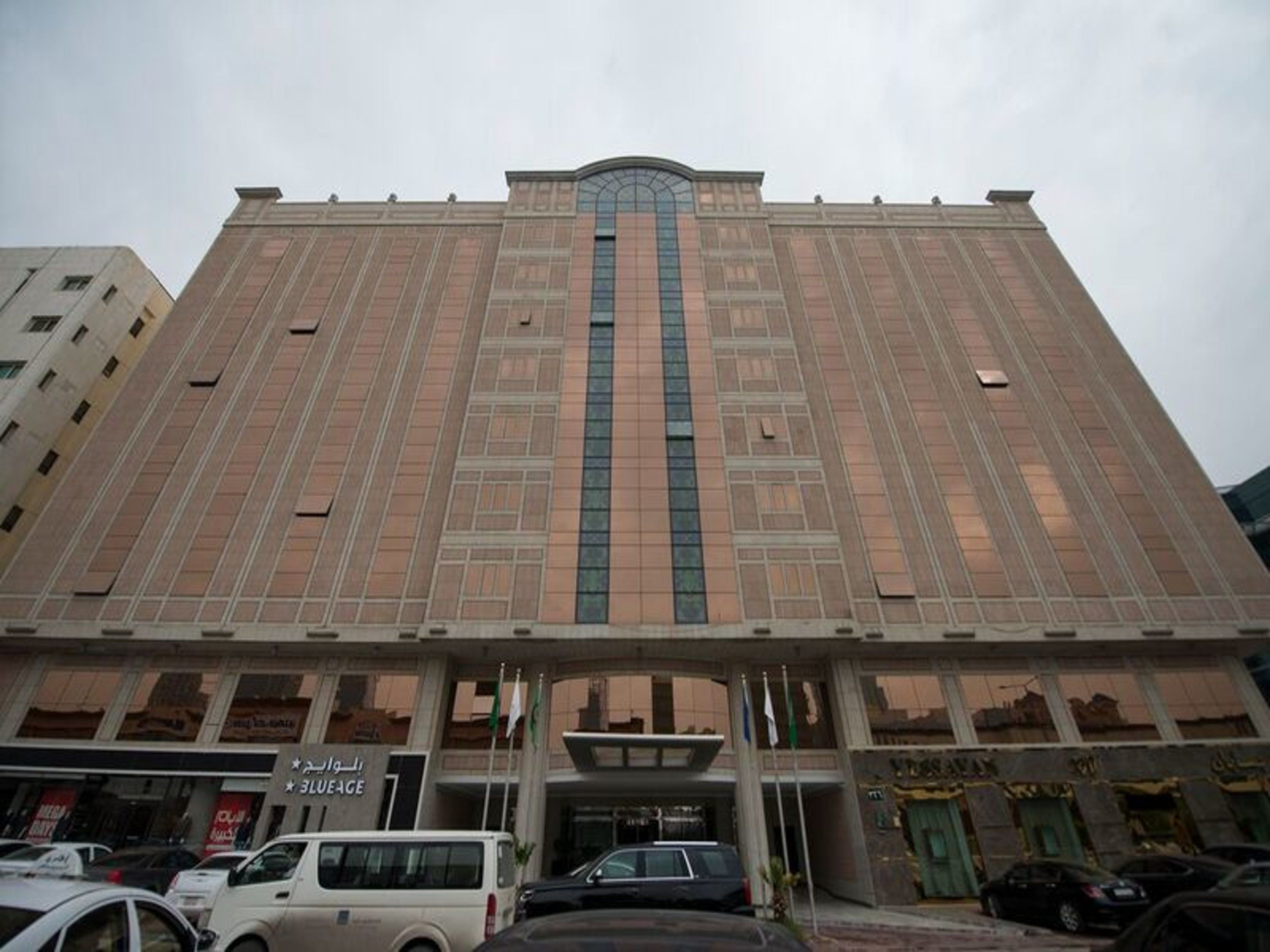 Un edificio grande de varios pisos con una entrada central y una fachada simétrica.