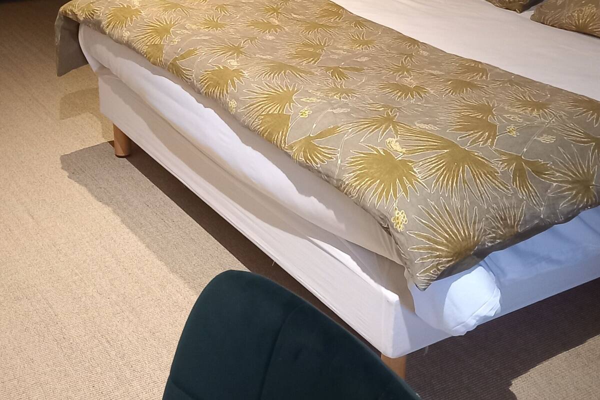 Une chambre à coucher avec un lit, une chaise, une armoire et une lampe.