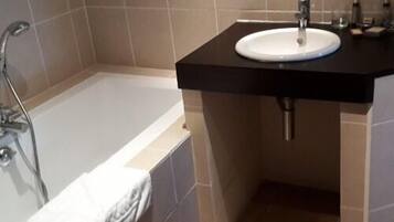 Une salle de bain avec une baignoire, un lavabo et une douche.