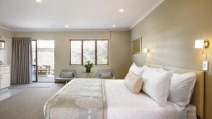 Un dormitorio amplio con una cama grande, un escritorio y una silla.