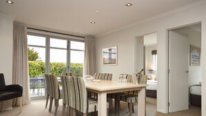 A dining area with a large table, chairs, and a view of the outdoors. - Beechtree Motel (Taupo)