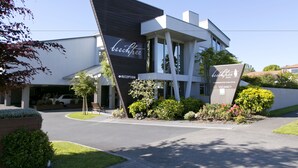 A modern building with a reception area and a sign indicating a vacancy. - Beechtree Motel (Taupo)