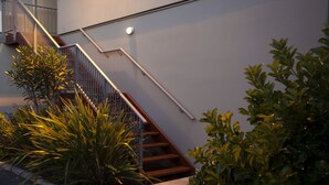 A staircase with metal railings and wooden steps leading up to a landing. - Beechtree Motel (Taupo)