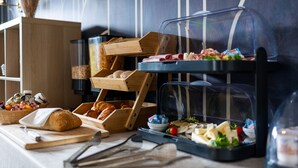 A breakfast buffet with various food items, including bread, pastries, and a salad. - Hotel Albert 1er (Cannes)