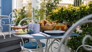A table set with breakfast items, including croissants, a basket, and a glass of orange juice. - Hotel Albert 1er (Cannes)
