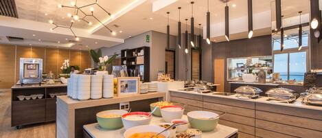 A buffet area with various food items and a coffee machine.