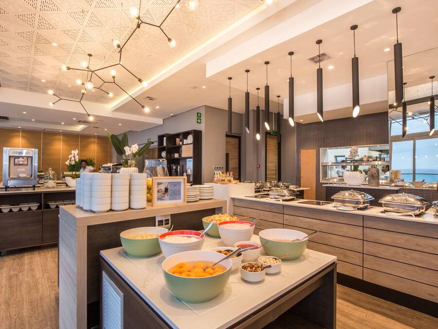 Zona de bufé con diferentes opciones de comida y una máquina de café.