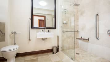 A bathroom with a toilet, sink, and shower area.