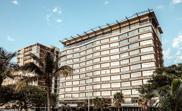 A multi-story hotel with a modern architectural design, featuring a series of balconies and large windows. - Belaire Suites (Durban)