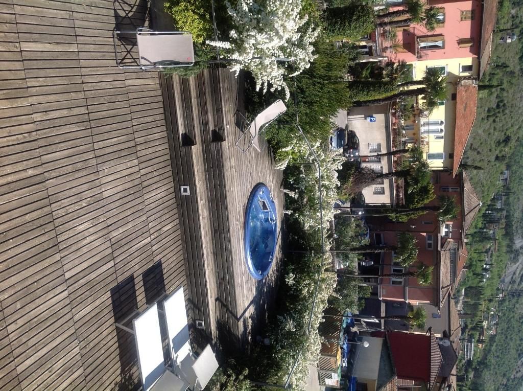 Ein Dachpool mit blauem Whirlpool, umgeben von Bäumen und Gebäuden.