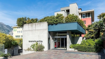 A modern building with a concrete facade and a sign reading "caminetto".