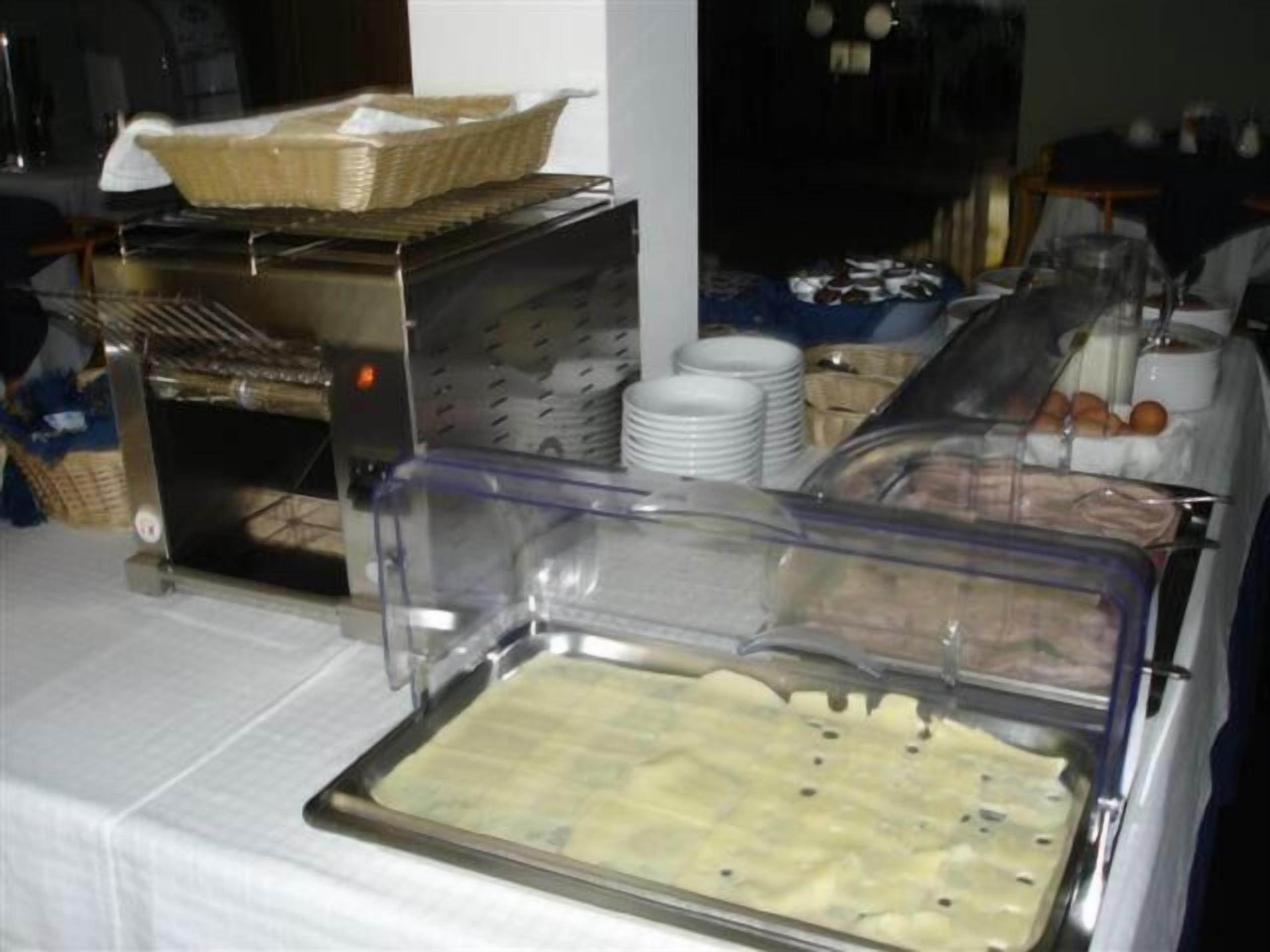 A buffet setup with various food items and utensils.