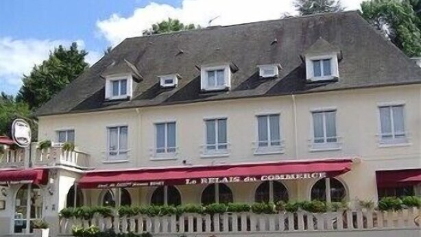 A two-story building with a red awning and a sign that reads "Le Relais du Coeur de l'Isle." - LOGIS HOTEL RESTAURANT DU COMMERCE (Pont-d'Ouilly)