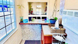 A compact kitchen with a window, a refrigerator, and a sink. - Relax Inn At Ashland (Ashland)