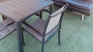 An outdoor patio with a table and chairs, a sofa, and a grill area. - Relax Inn At Ashland (Ashland)