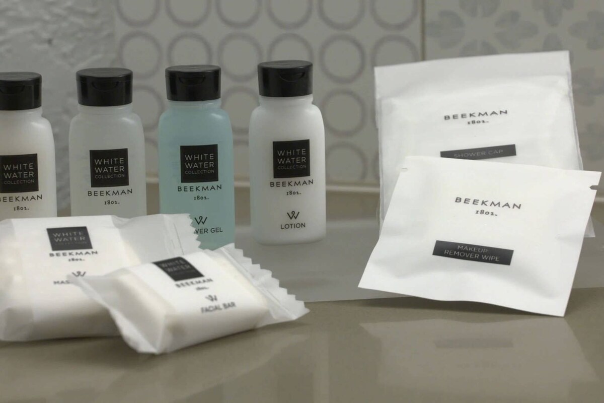A collection of skincare products from the Beekman brand, including lotion, facial bar, and shower cap.