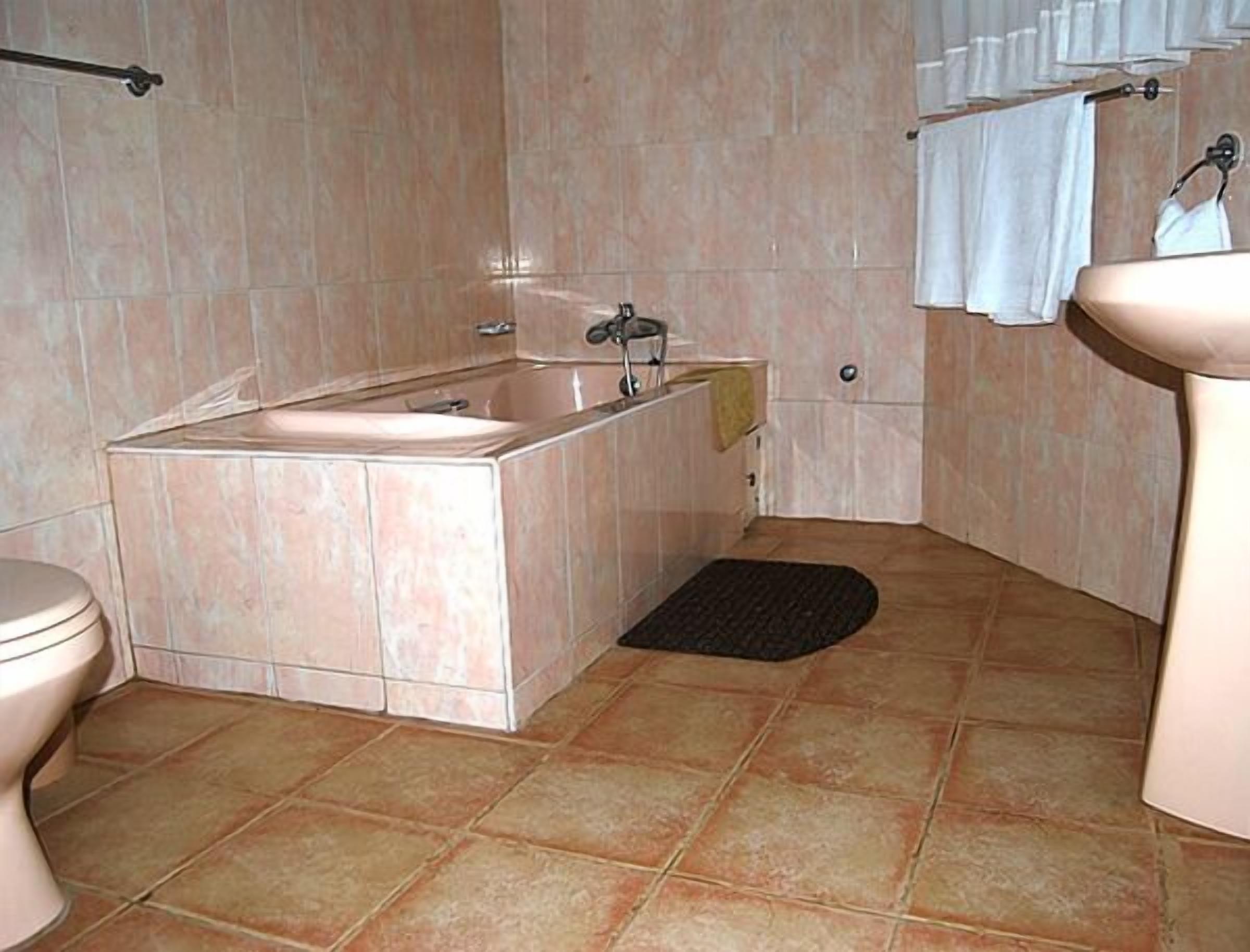 A bathroom with a sink, toilet, and bathtub.