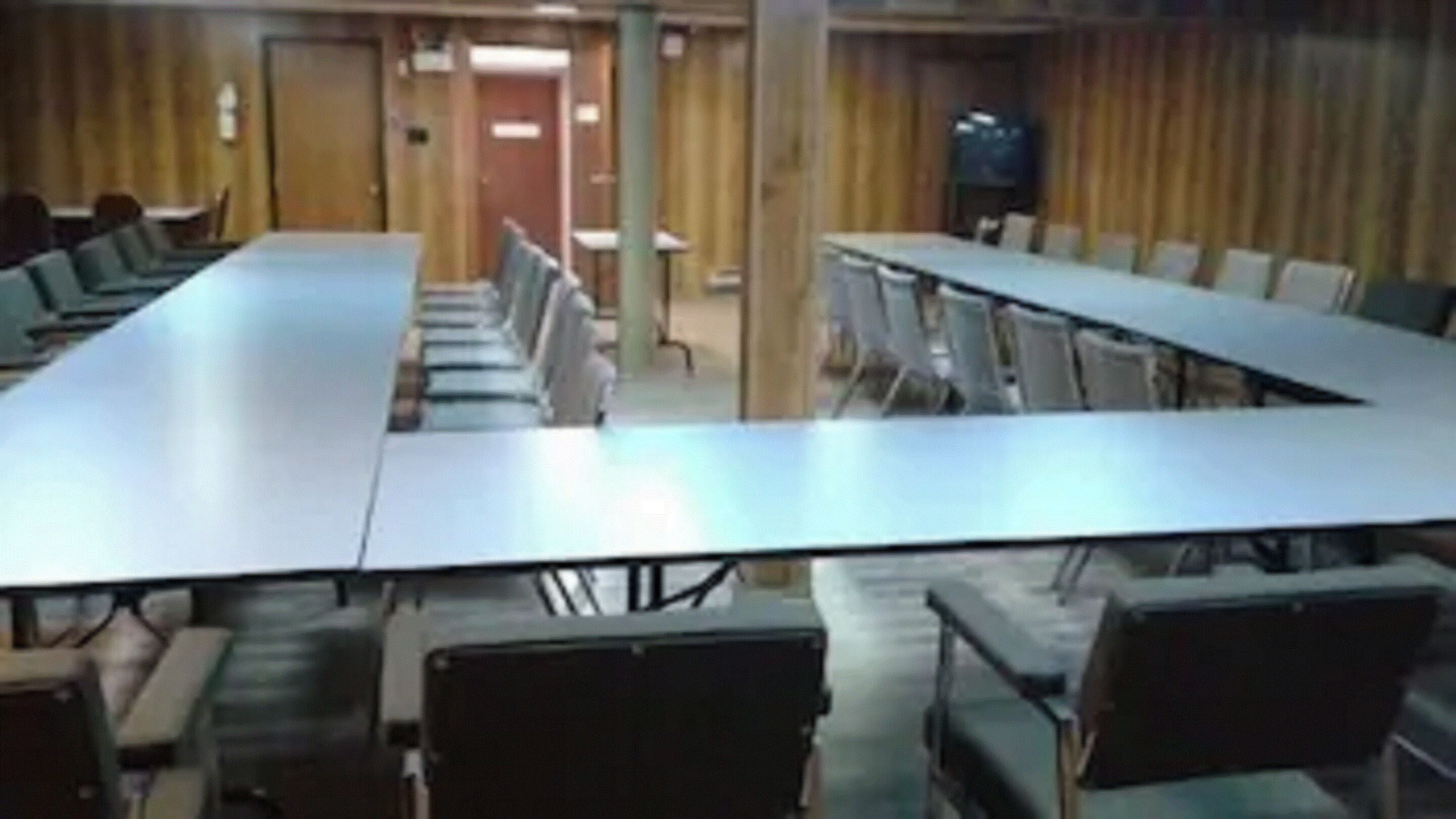 A conference room with a long table and multiple chairs.