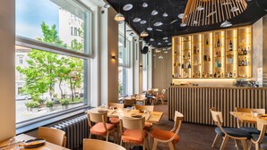 A restaurant with a bar area, wooden furniture, and a view of the street.