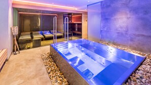 Zona d'spa moderna amb una banyera d'hidromassatge gran, sauna i bany de vapor.