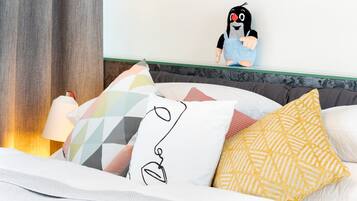 A bed with multiple pillows, a lamp, and a plush toy on the headboard.