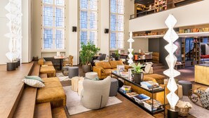 A spacious living area with a long sofa, a coffee table, and a bookshelf.