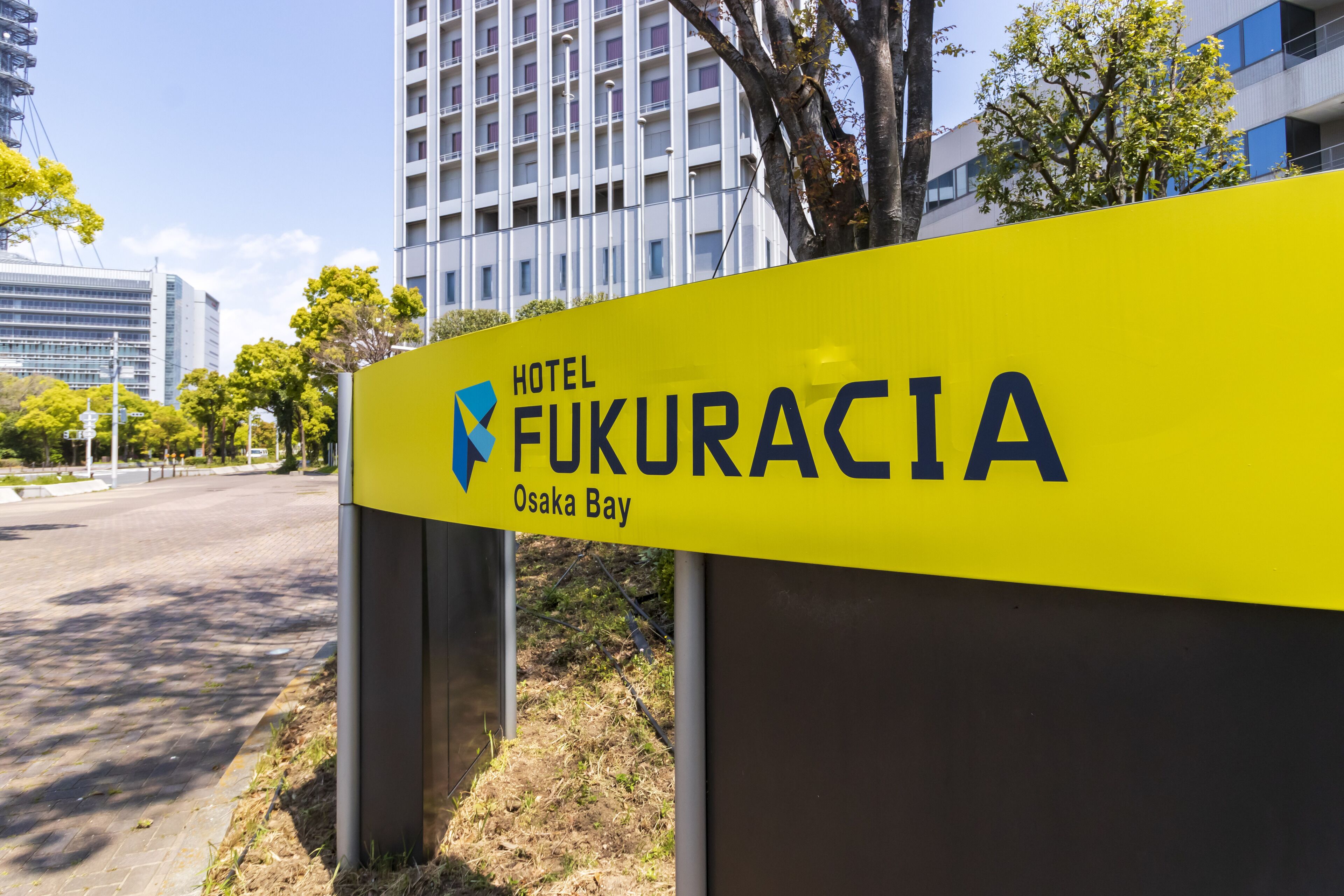 A yellow sign for Hotel Fukuracia in Osaka Bay.