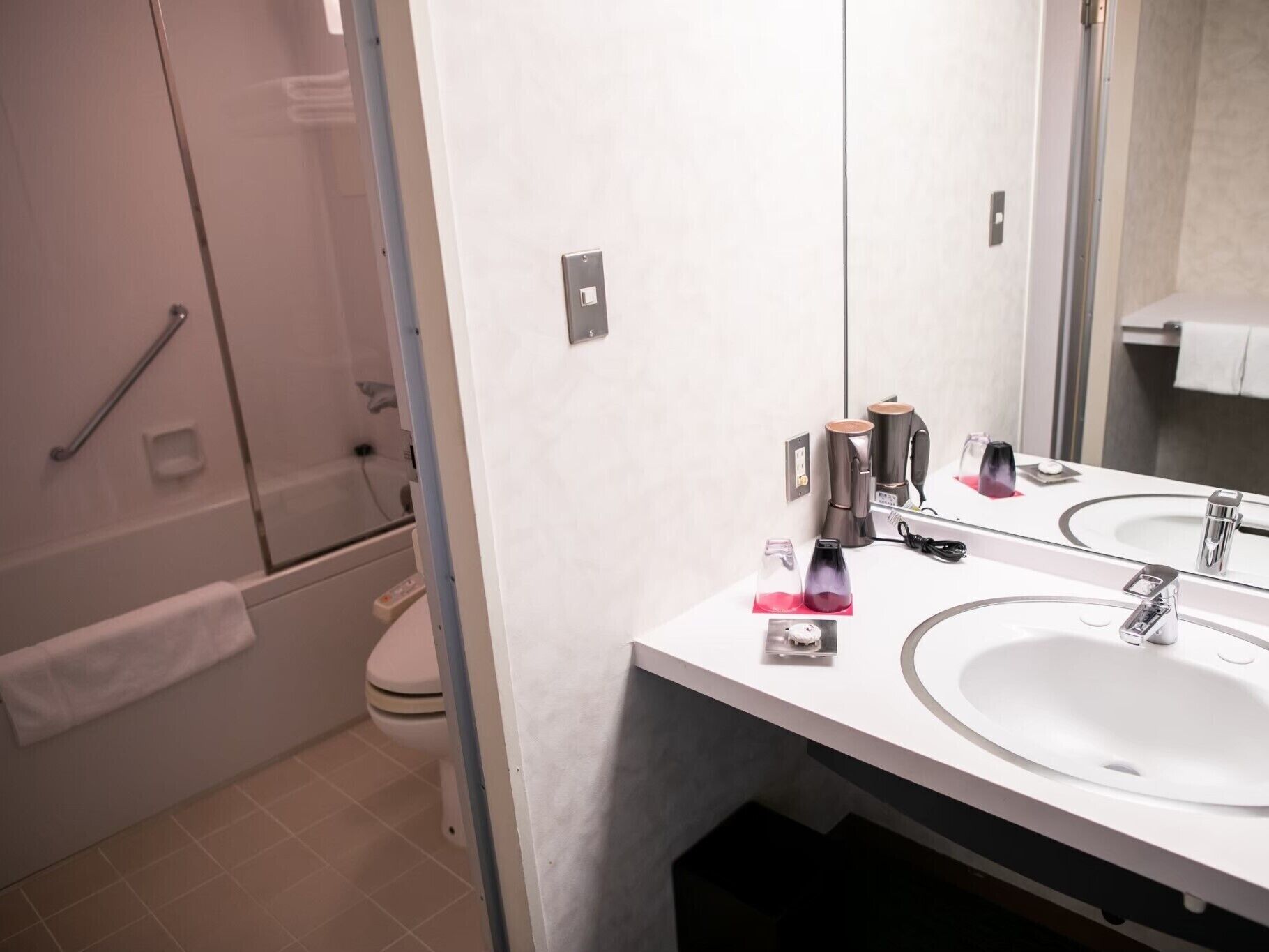 Un bagno moderno con uno specchio grande, due lavabi e una zona doccia.
