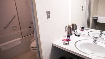 Un bagno moderno con uno specchio grande, due lavabi e una zona doccia.