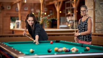 Enjoy a game of pool in our recreational area, featuring a pool table and comfortable seating.