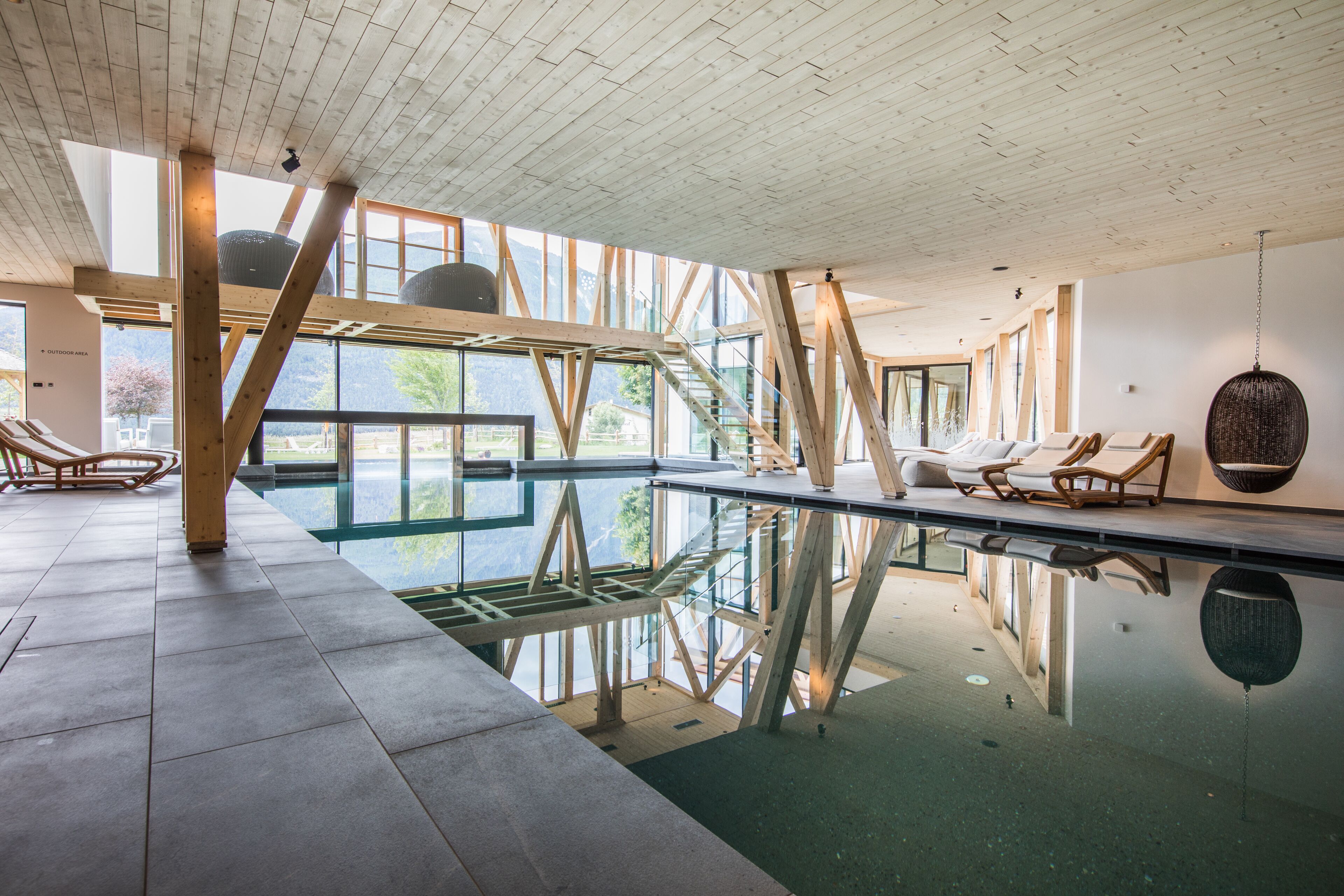 Una piscina cubierta, una piscina al aire libre, sombrillas, tumbonas