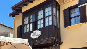 Exterior del Hotel Villa DanLin, con un letrero que anuncia un patio tranquilo y relajante.
