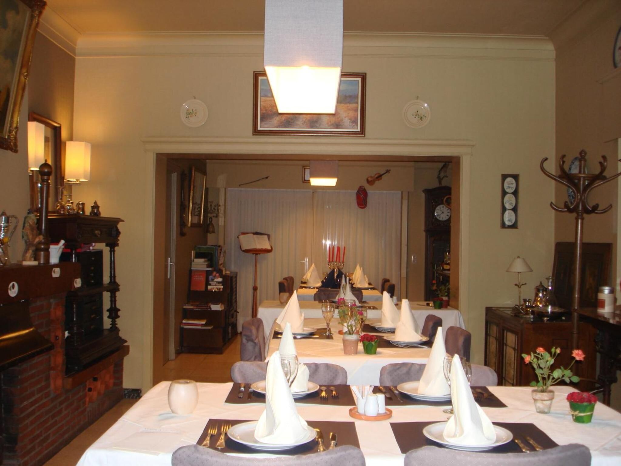 A dining area with a long table set for a meal, featuring white napkins, plates, and cutlery.