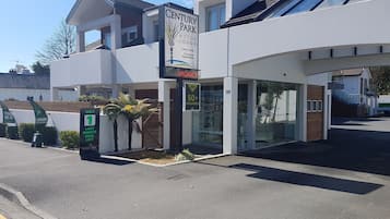 Un motel Century Park avec une enseigne indiquant « Chambres disponibles » et « Appartements de luxe, logements de standing ».