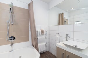 Un baño moderno con bañera, ducha y lavabo.