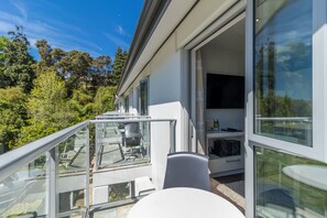 A modern house with a balcony, large windows, and a dining area. - Century Park Motor Lodge (Nelson)