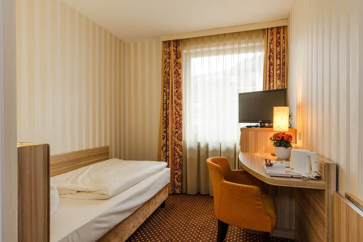 Eenpersoonskamer | Een minibar, een kluis op de kamer, een bureau, geluiddichte muren