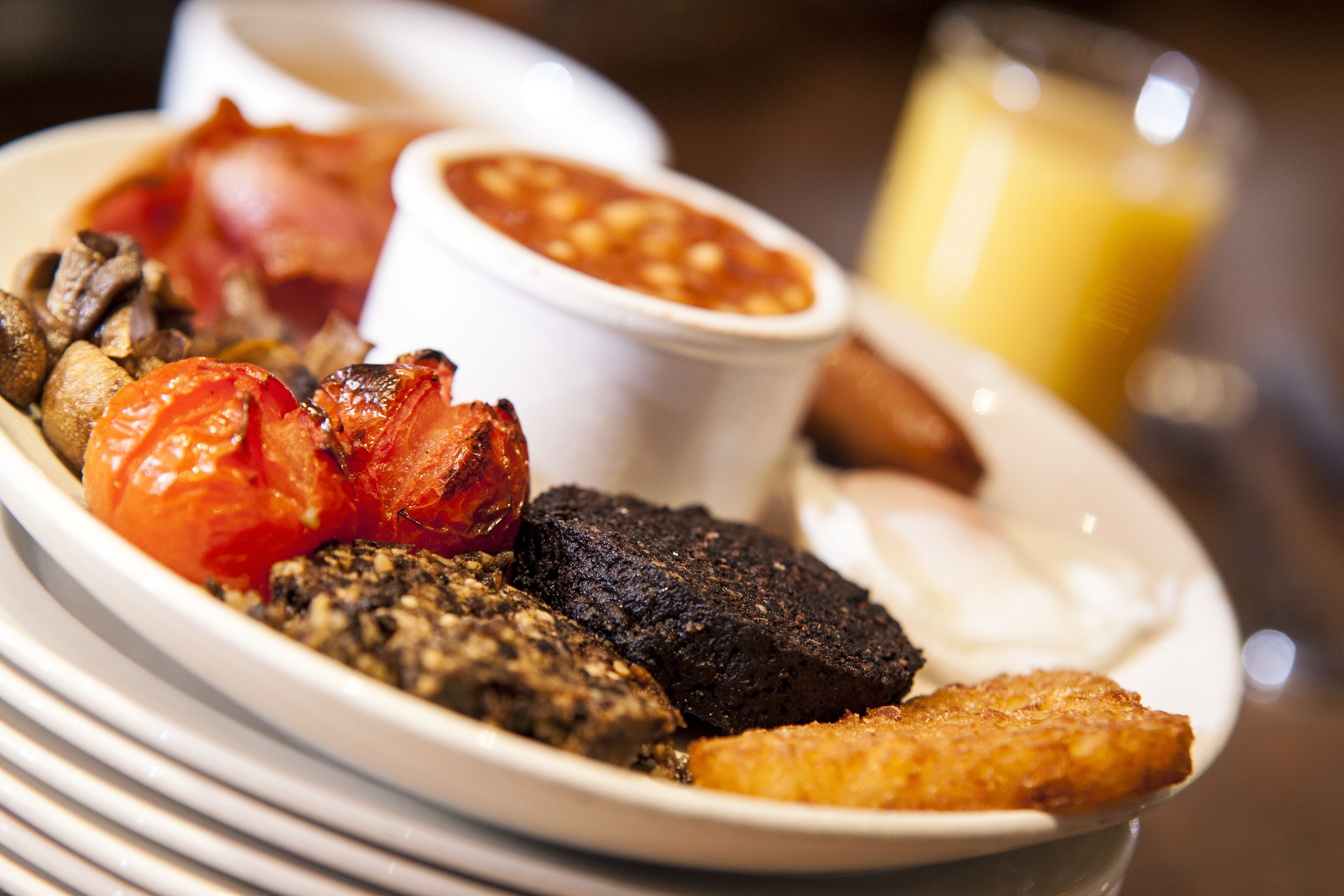 Un plato de desayuno con huevos, tocino, tomates y tostadas.