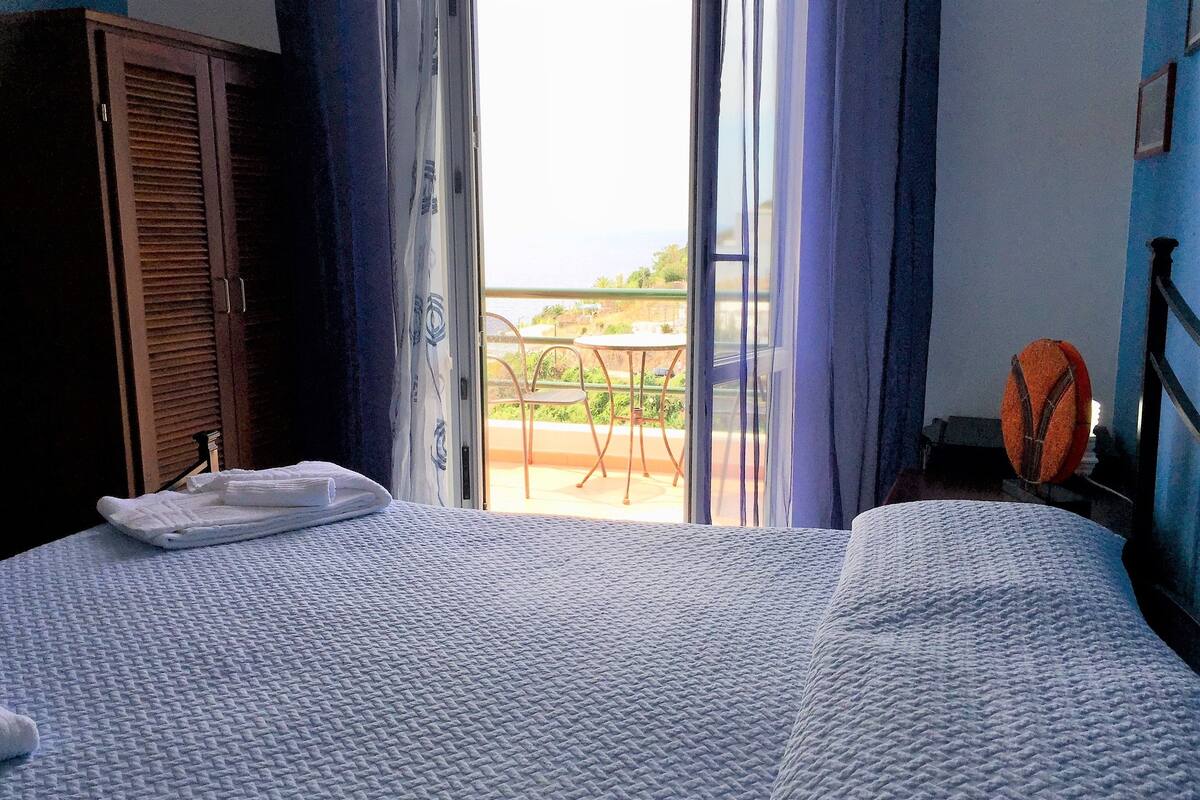 Une chambre d’hôtel avec un lit, une armoire et une vue sur l’extérieur.