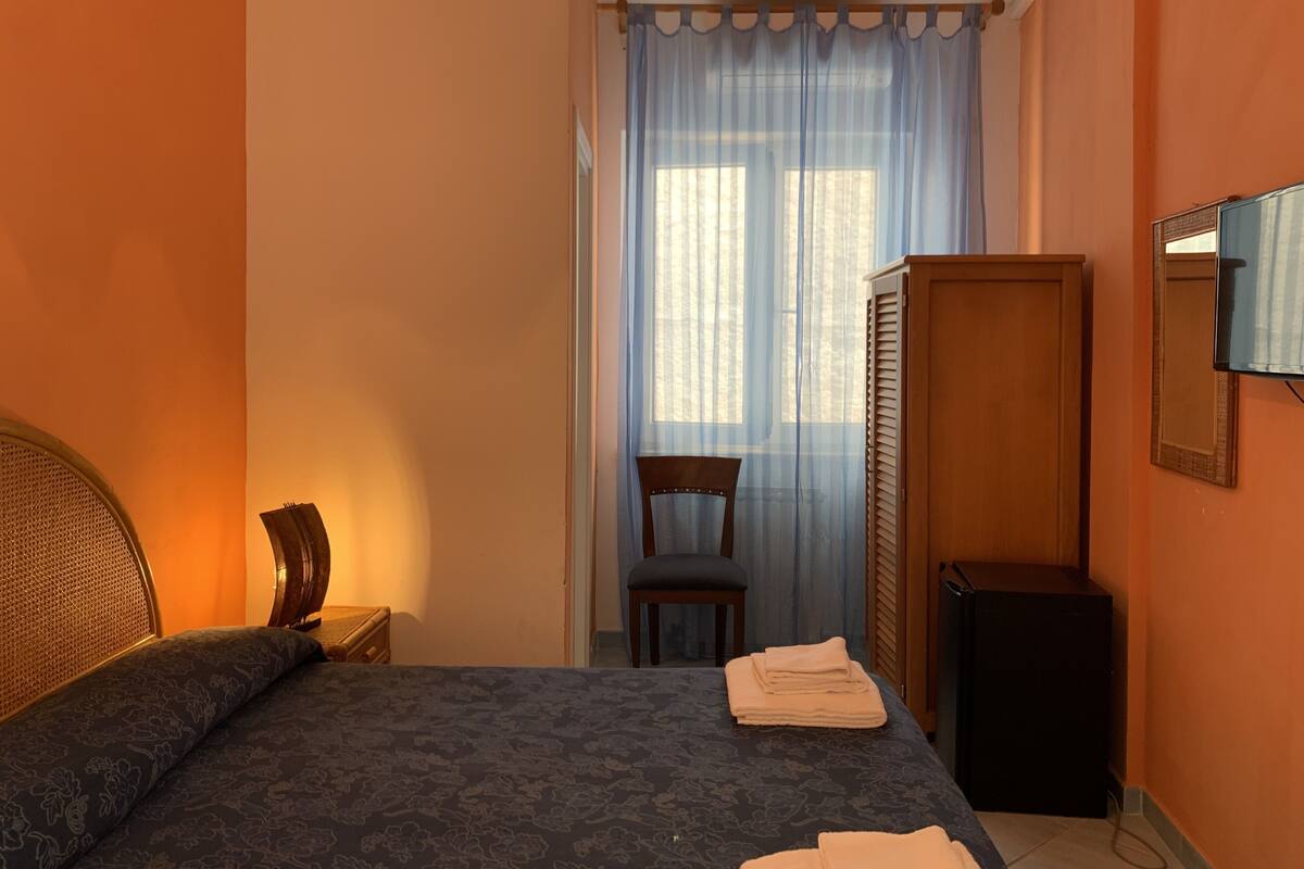 Une chambre à coucher avec un lit, une chaise, une armoire et un miroir.