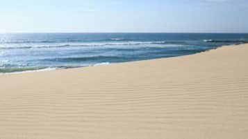 A beach with a wide sandy area and the ocean in the background.