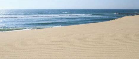 A beach with a wide sandy area and the ocean in the background.