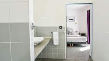 Un baño moderno con un lavamanos blanco, un perchero y una cortina de ducha.