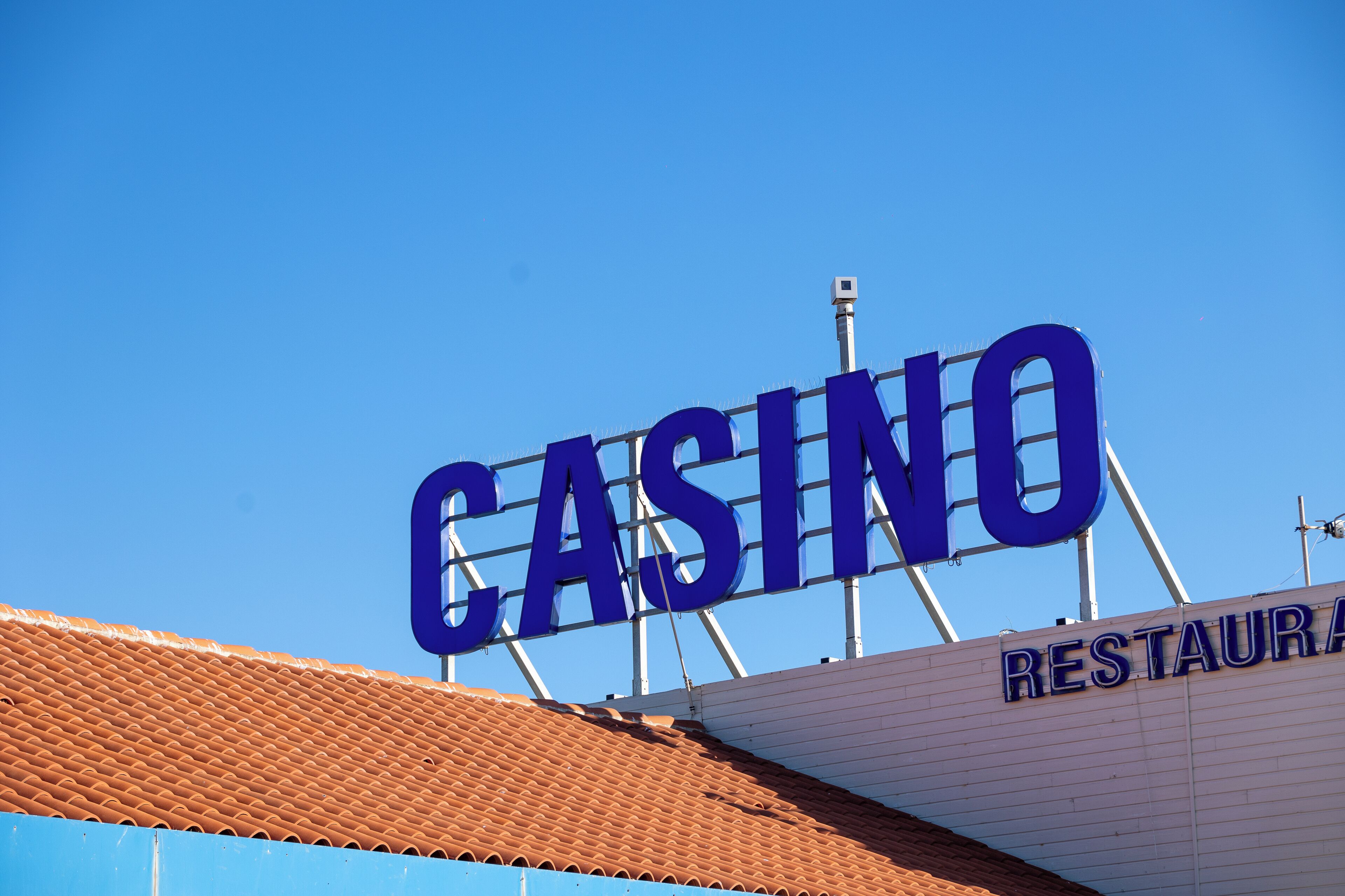 Ein großes, blaues Schild mit dem Wort 'CASINO' vor strahlend blauem Himmel.