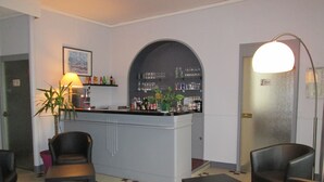 Uma área de bar com balcão, cadeiras e um vaso de planta.