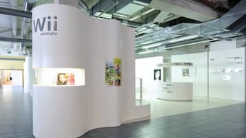 A modern, white kiosk with 'Wii Move You' branding, featuring a magazine rack and promotional posters.
