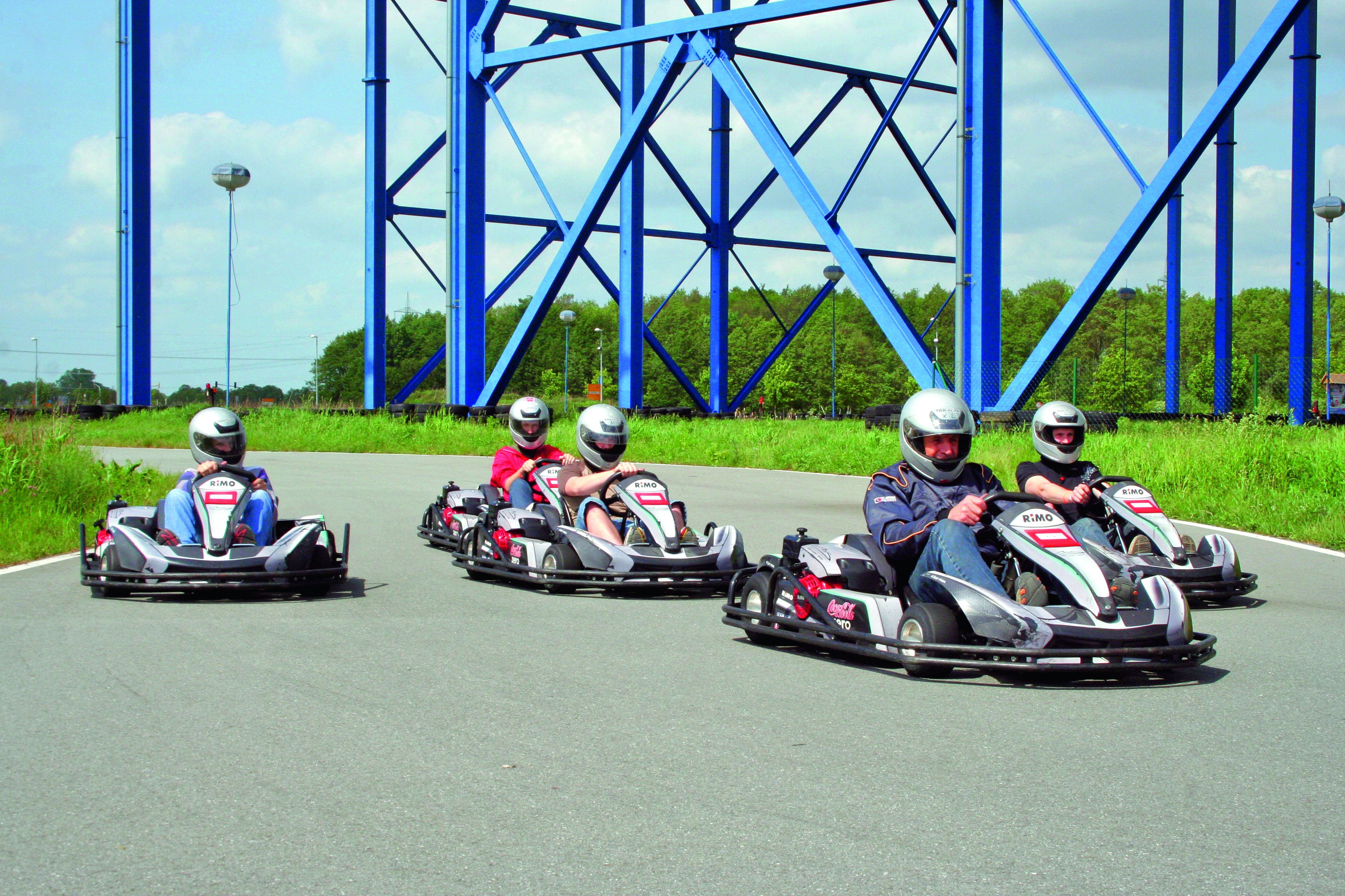 A go-kart track with blue metal structures in the background.