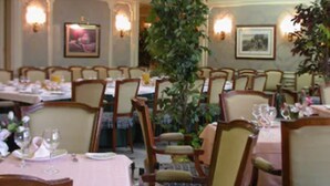 A dining area with tables set for meals, chairs, and wall-mounted lights.