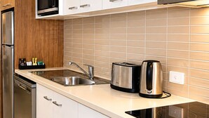A modern kitchen with stainless steel appliances, a built-in microwave, and a toaster. - Quest Mildura (Mildura)